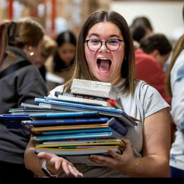 Rhianna Furness, a senior special education major, reacts to the stack of books she picked out.